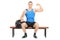 Muscular athlete showing his bicep seated on a bench