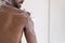 Muscular back of mixed race African bearded guy, taking shower