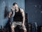 Muscular bodybuilder drying his face after workout in a gym