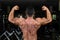 Muscular bodybuilder showing his back double biceps