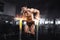 Muscular bodybuilder working out in gym doing exercises on burning fire parallel bars. Concept sport