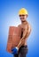 Muscular builder with bricks against gradient