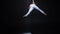 Muscular circus aerialist on the aerial straps in black studio