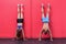 Muscular couple doing handstand exercises