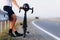 Muscular cyclist relaxing on asphalt road after racing