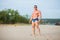 Muscular fit guy on sandy river beach. Strong athlete relax on a summer day.