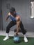 A muscular and fit man grasps a heavy kettlebell, about to do overhead presses or swings. High Intensity training at the gym