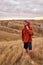 Muscular guy in casual hoodie wearing hood, stand having rest, relaxing alone in field