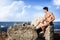 Muscular guy sitting on the rock, mediterranean Sea