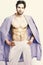 Muscular guy with torso and six packs in home or bath clothes. Morning and masculinity concept. Macho in blue bathrobe