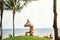 Muscular healthy man doing yoga in tropical nature