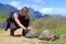 Muscular hiker touches turtle