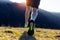 Muscular legs of the athlete runner from behind during the racing race in the mountain trail