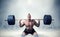 Muscular male weightlifter exercise with barbell