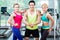 Muscular man amongst two sportive women striking pose