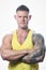 Muscular man with blue eyes and tattoo in the yellow tank top on the white background