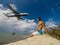 Muscular man on the coast watching landing of airplane flying over the sea of caribbean sea. Montego Bay. Jamaica. 2017