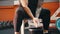 A muscular man covering his hands in talcum and clapping it - sitting in the gym