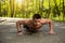 Muscular man is doing push-ups in wood