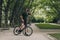 Muscular man drinking water after morning cycling at park