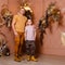 Muscular man and eight-year-old boy in brown interbreeding decorated with dried flowers. father and son