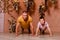 Muscular man and eight-year-old boy in brown interbreeding decorated with dried flowers. father and son