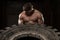 Muscular Man Exercising Crossfit Workout By Tire Flip