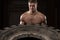 Muscular Man Exercising Crossfit Workout By Tire Flip