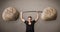 Muscular man lifting large rock stone weights