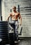 Muscular man in military pants posing in a gym.