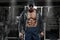 Muscular man with open jacket revealing chest and abs in gym, workout