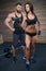 Muscular man with tattoos and beard and beauty girl posing in gym