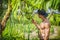 Muscular man touching banana tree