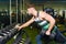 Muscular man training in the gym. young guy picks up a dumbbell near the mirror.