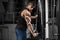 Muscular man working out in gym doing exercises at triceps, strong male