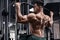 Muscular man workout in gym, doing exercise for back. Strong male rear view