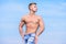 Muscular masculine guy look confident. Man muscular bare torso stand outdoor blue sky background. Man muscular