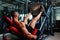 muscular men using a leg press machine and placing his legs on the platform on a dark colorful background.