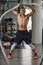 Muscular powerful aggressive man training with rope in functional training fitness gym. Motion blur