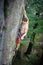 Muscular rock climber climbs on overhanging cliff