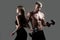 Muscular sexy couple body. Sports people are working out with dumbbells. Fit couple doing exercise with dumbbells in