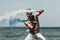 muscular shirtless man dancing with blue and white smoke sticks in front