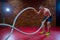 Muscular Shirtless Man in a Gym Exercises with Battle Ropes During His Fitness Workout High-Intensity Interval Training.