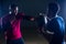 Muscular shirtless young african american man in sportswear tire exercising with tyre in gym on a black background in