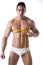 Muscular shirtless young man measuring chest and pecs with tape measure