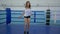 Muscular sportswoman in short shorts using jumping rope to stay fit on boxing ring