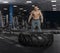 Muscular,Strong bodybuilder pushing tire in modern fitness cente