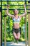 Muscular strong woman on the crossbar is engaged in the park