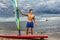 Muscular surfer posing with surfboard.