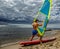 Muscular surfer posing with surfboard.